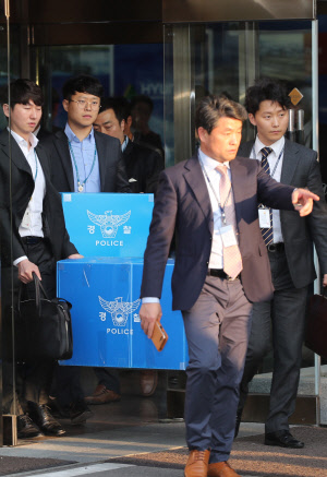 지난 25일 종로구 현대건설 본사에서 경찰이 압수수색 자료를 담은 박스를 들고나오고 있다.   연합뉴스